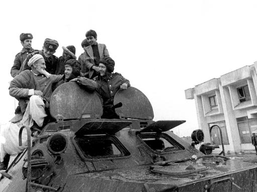 Afghanische Männer verbrüdern sich mit sowjetischen Sodlaten auf einem sowjetischen Panzer, aufgenommen in Hairhana im März 1980. 