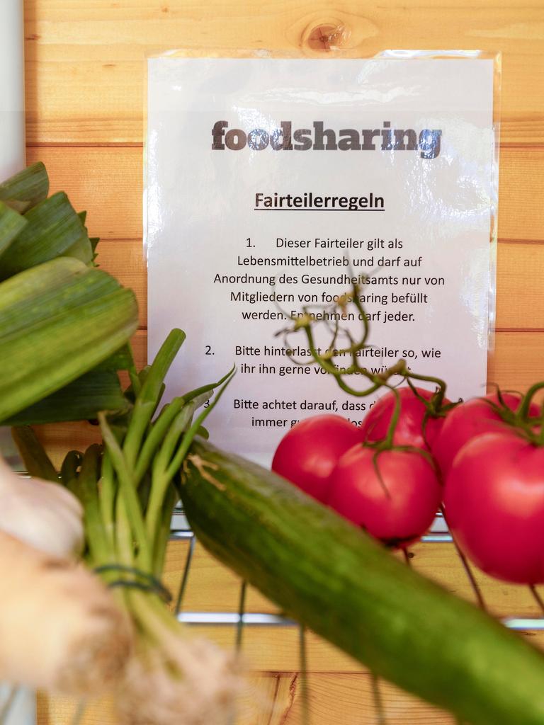Lauch, eine Gurke und Tomaten liegen in einem Fach, dahinter hängt ein Zettel, auf dem "foodsharing" steht.
