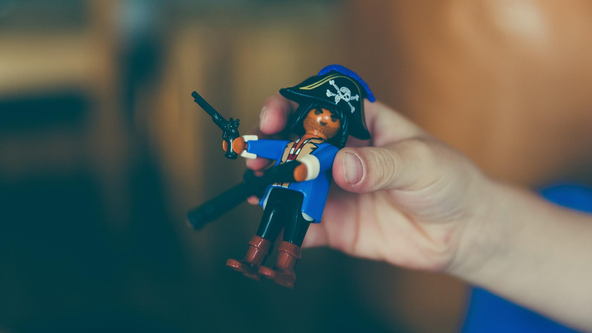 Eine Hand hält ein Playmobil-Piratenmännchen.