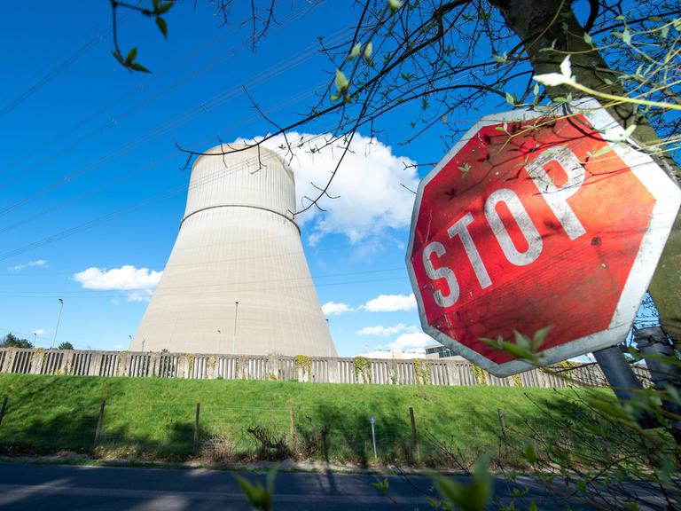 Auf einer Straße, von der aus das Kernkraftwerk Lingen zu sehen ist, steht am Straßenrand ein Stoppschild.