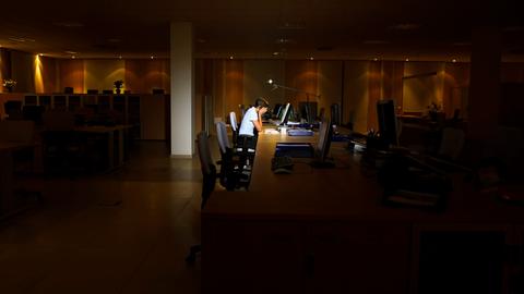 Müde einsame Person vor einem Bürorechner.
