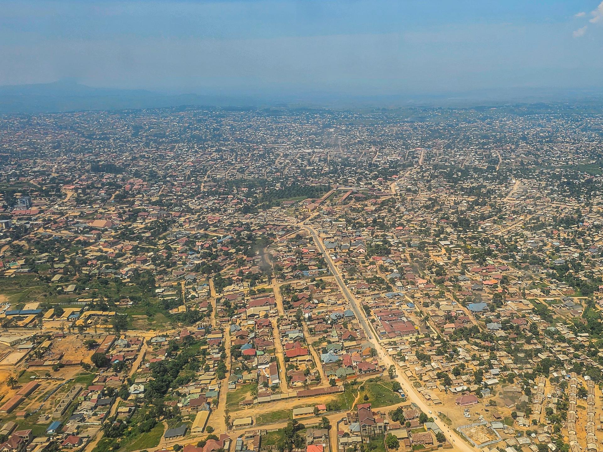 Luftaufnahme der Region um Goma im Kongo. Kleine Häuser und helle, sandinge Straßen sind zu erkennen.