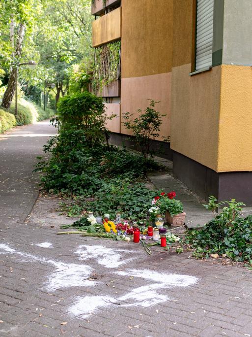An einer Hausecke liegen Kerzen und Blumen zum Gedenken.