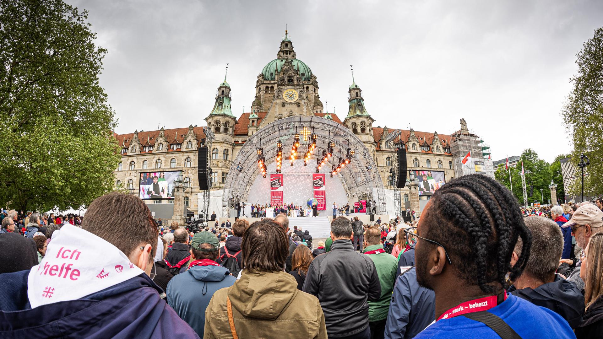 Menschen stehen vor einer Frei-Licht-Bühne. Dahinter ist die Fassade von dem Rathaus. Menschen stehen vor einer Frei-Licht-Bühne. Dahinter ist die Fassade von dem Rathaus.