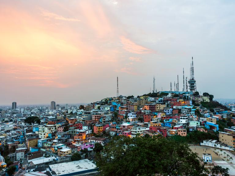 Ein Panoramablick auf Guayaquil, die größte Stadt Ecuadors. Man sieht viele farbige Häuser auf einem Berg.