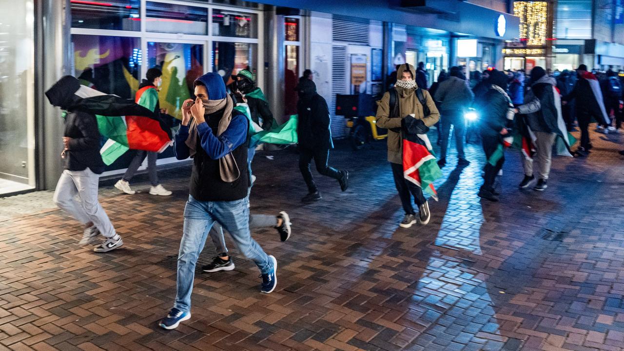 Vermummte Menschen mit Palästina-Flaggen am Donnerstagabend in Amsterdam.