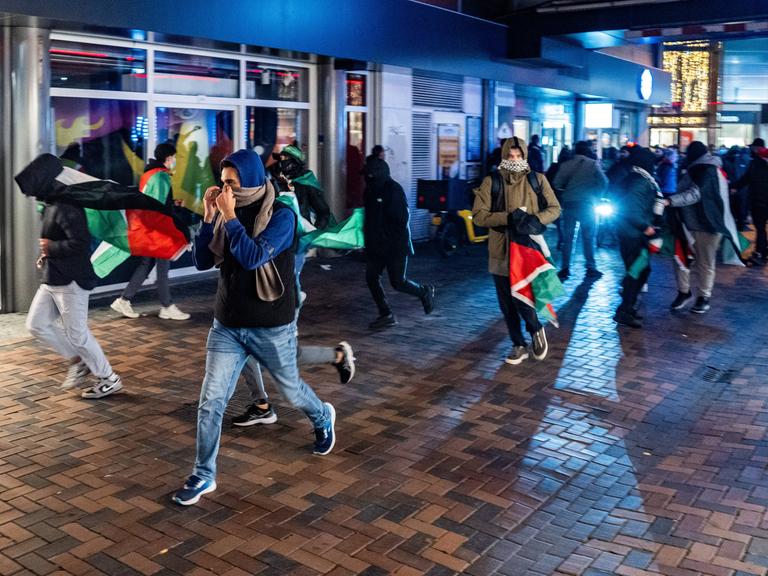 Vermummte Menschen mit Palästina-Flaggen am Donnerstagabend in Amsterdam.