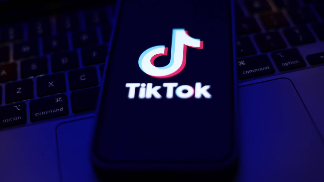 Tiktok-Logo auf einem Smartphone, das auf einer Computertastatur liegt.