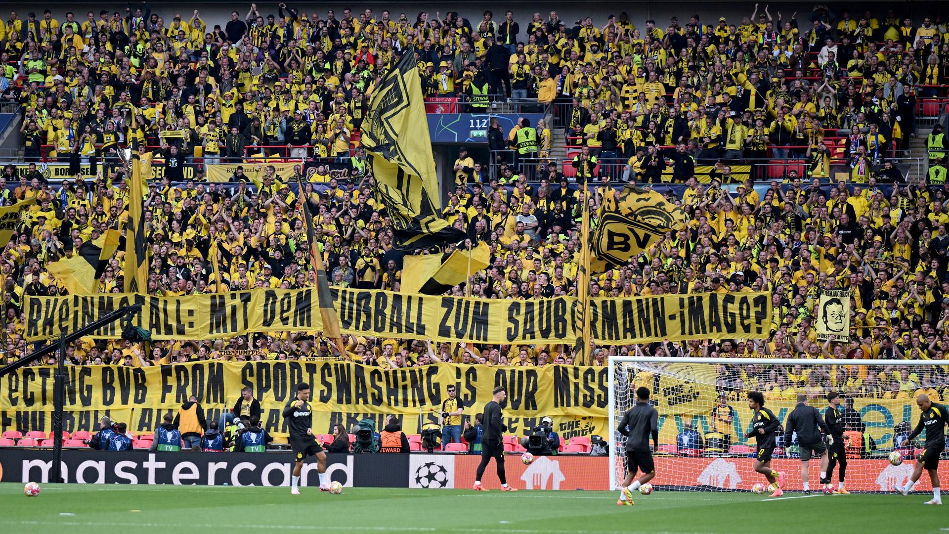 Rheinmetall-Sponsoring: Fans von Borussia Dortmund halten vor dem Championsleague-Finale gegen Real Madrid ein Spruchband "Rheinmetall. Mit dem Fußball zum Saubermann-Image?" in die Höhe.