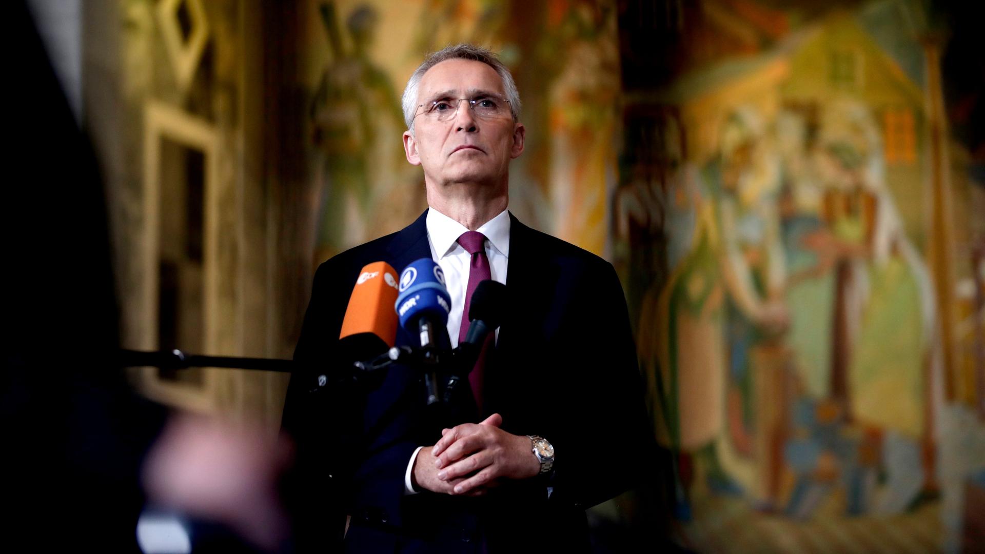 NATO-Generalsekretär Stoltenberg steht vor Mikrofonen und gibt ein Statement.