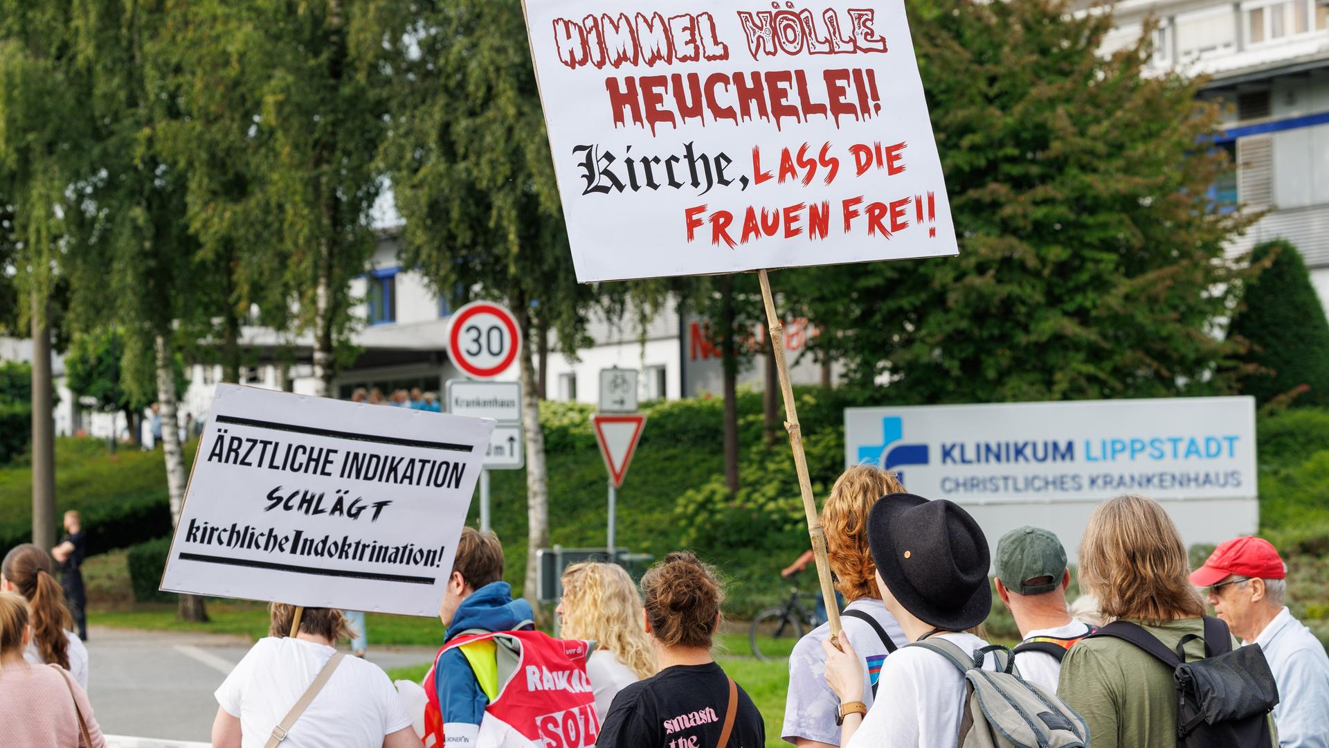Demonstranten zeigen Plakate gegen das von der katholischen Kirche verhängte Verbot von Schwangerschaftsabbrüchen vor dem Klinikum Lippstadt - Christliches Krankenhaus. 