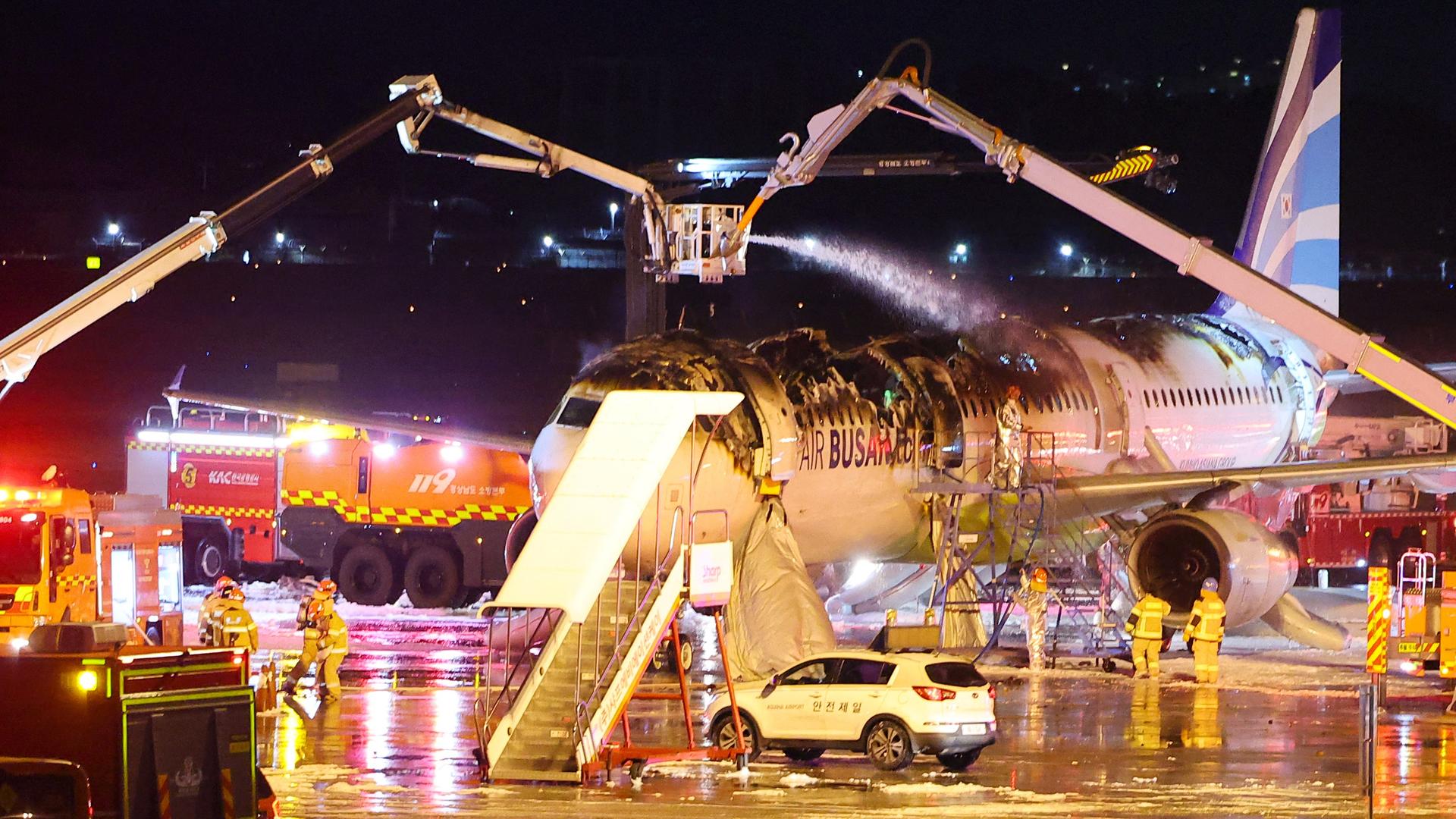 Feuerwehrleute löschen die Maschine auf dem Gimhae International Airport in Busan, die Feuer fing.