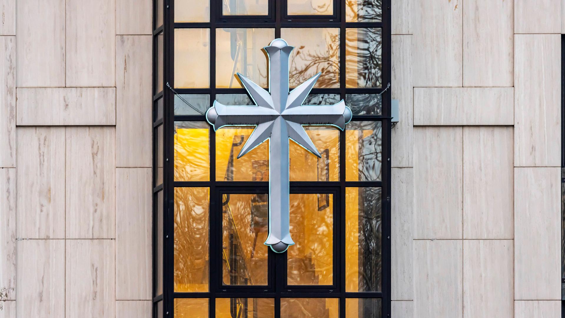 Das Logo von Scientology, ein Kreuz angebracht an der Fassade vom Sitz der Bewegung in Stuttgart.