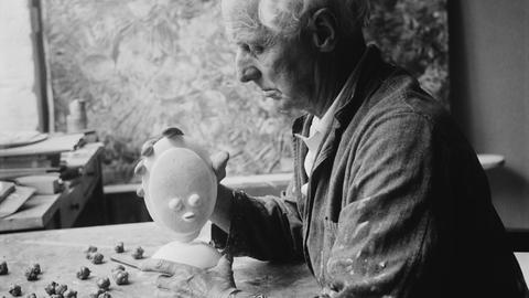 Der deutsche Künstler Max Ernst mit einer kleinen Skulptur in Frankreich, circa 1955.