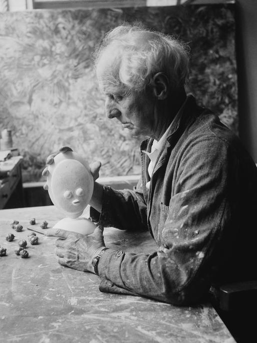 Der deutsche Künstler Max Ernst mit einer kleinen Skulptur in Frankreich, circa 1955.