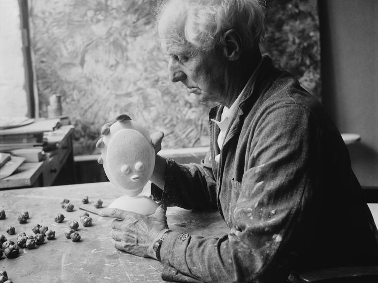 Der deutsche Künstler Max Ernst mit einer kleinen Skulptur in Frankreich, circa 1955.