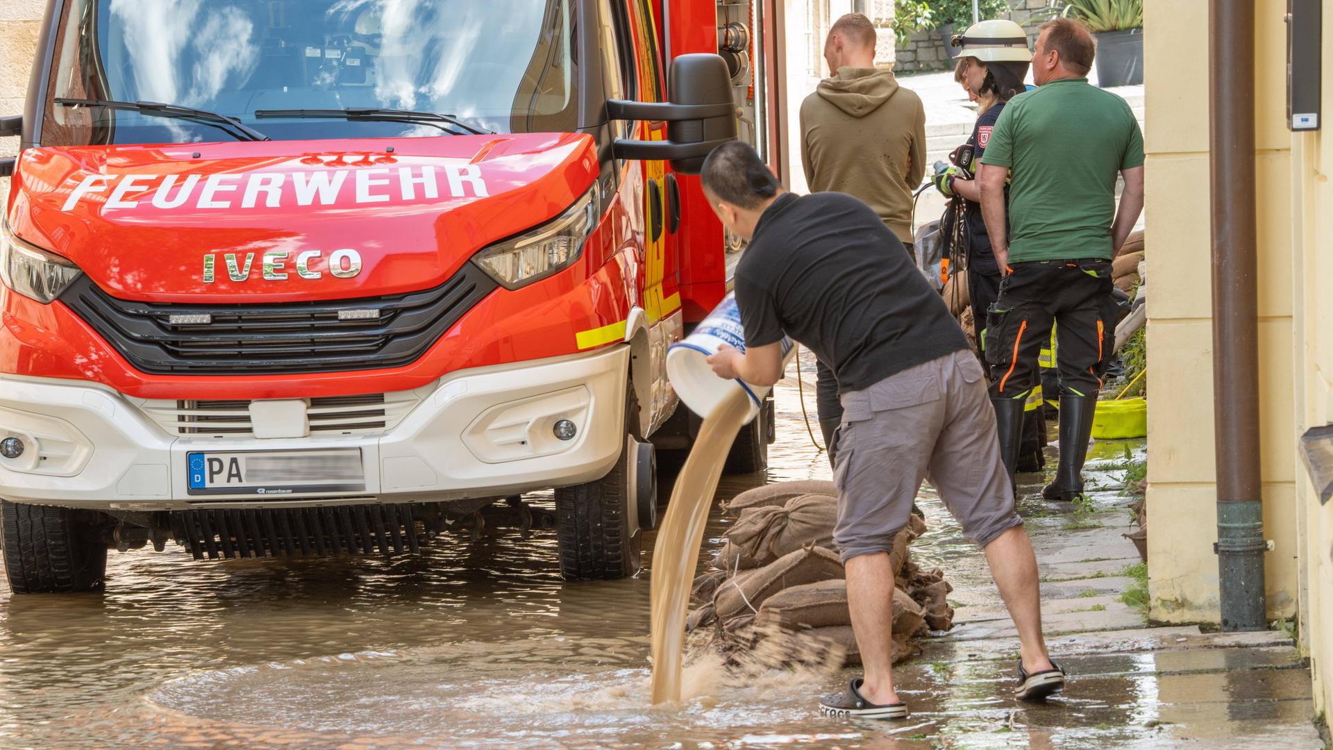 Restaurantkräfte und Feuerwehr arbeiten zusammen, um ein Lokal in Ufernähe in Passau von Wasser zu befreien. Die Passauer Altstadt steht im Uferbereich immer noch unter Wasser.