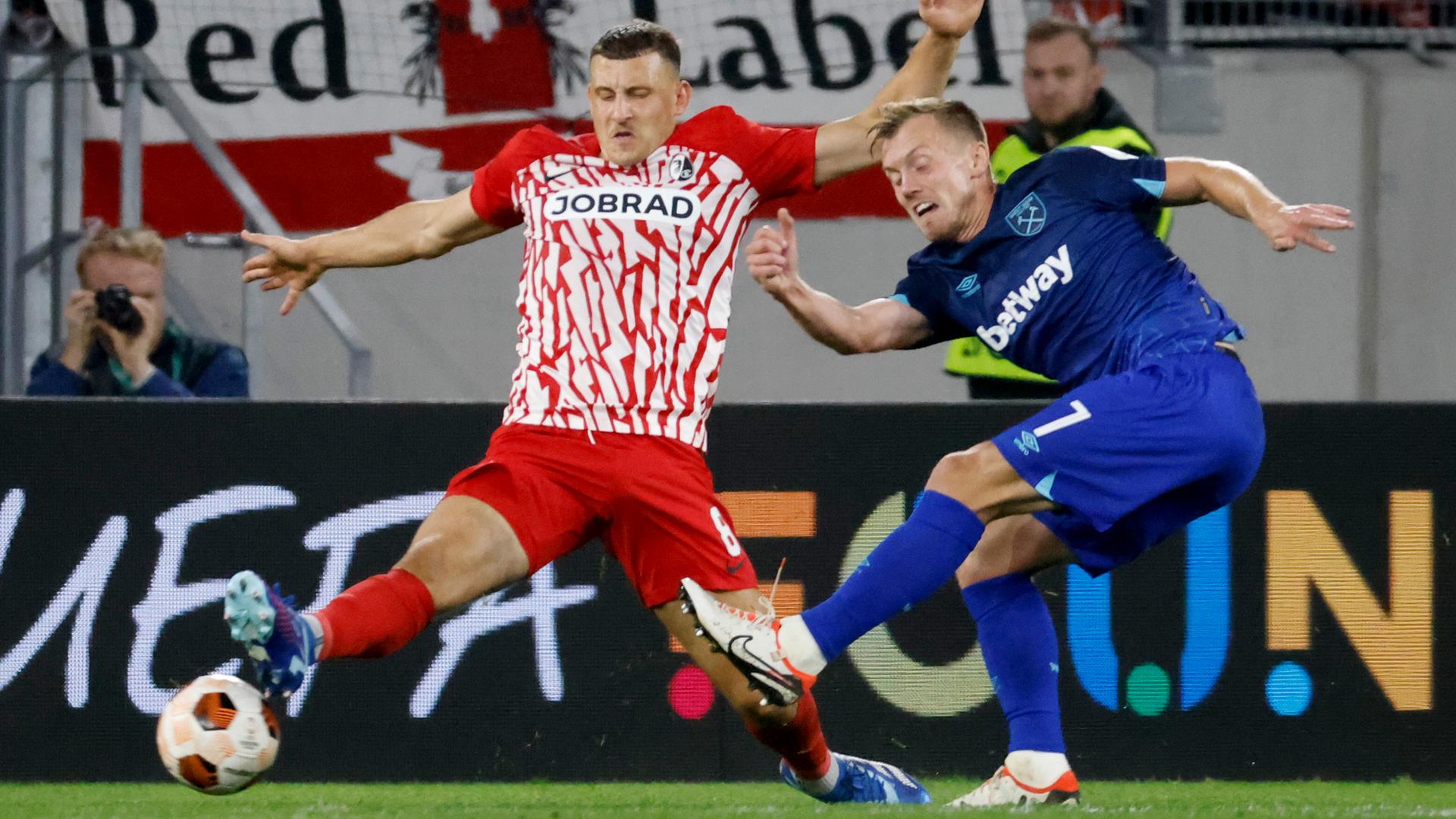 Der Freiburger Fußballer Maximilian Eggestein und West Hams James Ward-Prowse kämpfen während eines Europa-League-Spiels um den Ball.