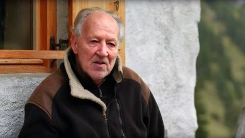 Werner Herzog sitzt vor einem Haus (Aufnahme aus dem Jahr 2022).