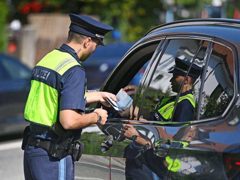 Polizisten kontrollieren Fahrzeuge und Fahrzeugpapiere. 