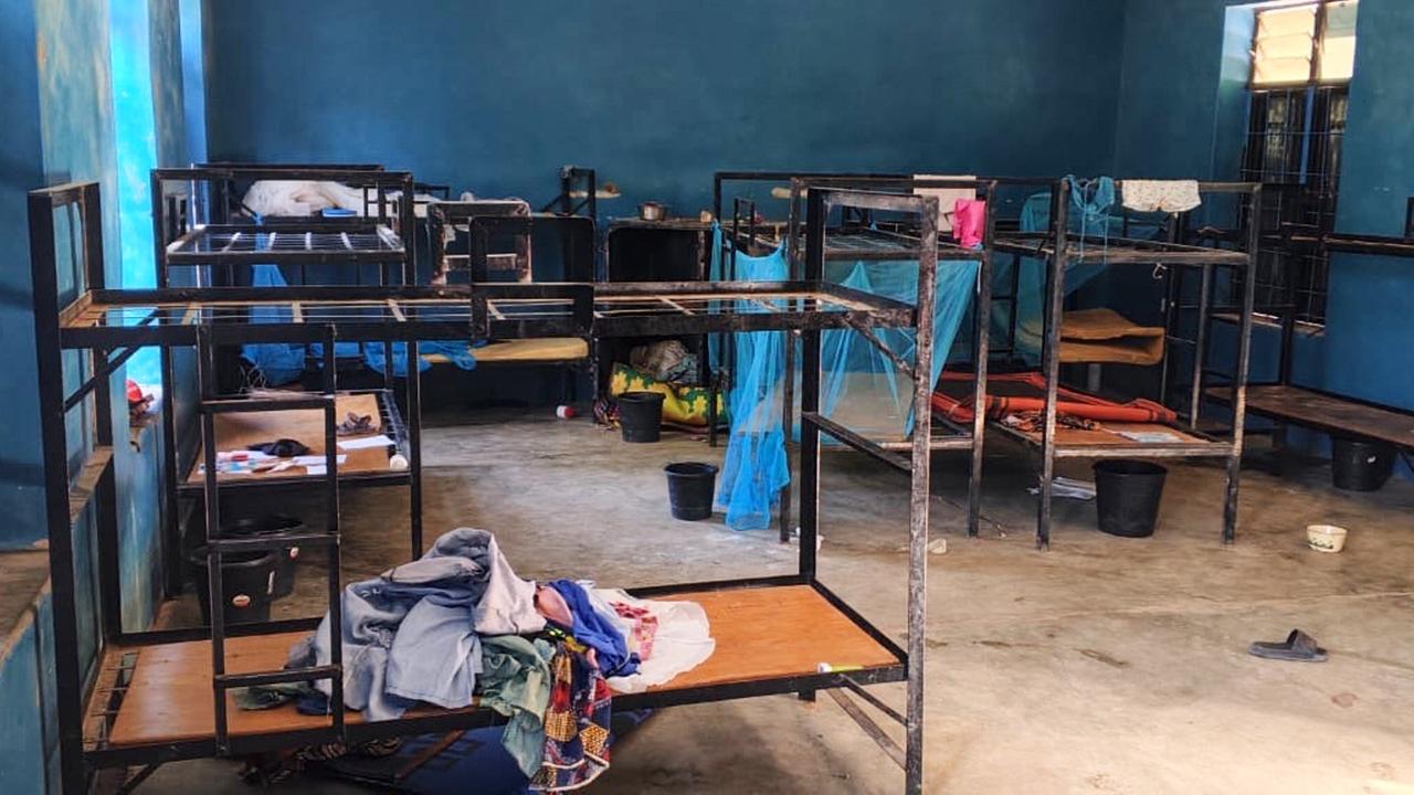 Blick in den Schlafraum mit leeren Stockbetten. darauf löiegen zurückgelassene Kleider. 