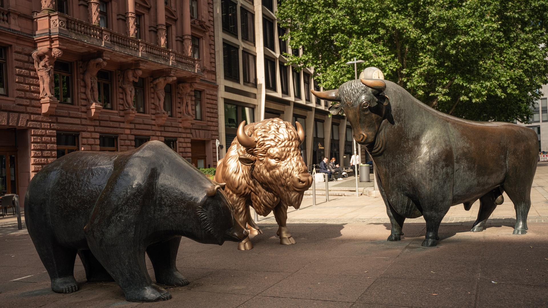 Auf dem Frankfurter Börsenplatz ist zwischen Bulle und Bär, den traditionellen Symbolen für die Börse, eine goldene Bison-Plastik zu sehen.
Auf dem Frankfurter Börsenplatz ist zwischen Bulle und Bär, den traditionellen Symbolen für die Börse, eine goldene Bison-Plastik zu sehen.