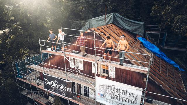 Fünf Freunde aus Saarbrücken auf einem Gerüst vor ihrer gemeinsamen Villa.