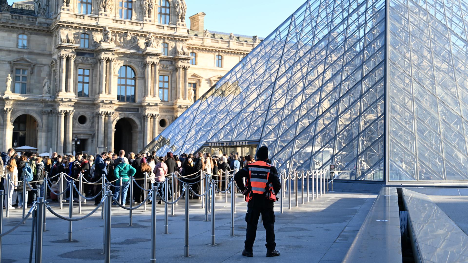 Menschen stehen Schlange, um das Louvre-Museum zu betreten. Im Pariser Louvre muss wegen baufälliger Fußböden ein Ausstellungsbereich vorsorglich und unerwartet für Besucher geschlossen werden. 