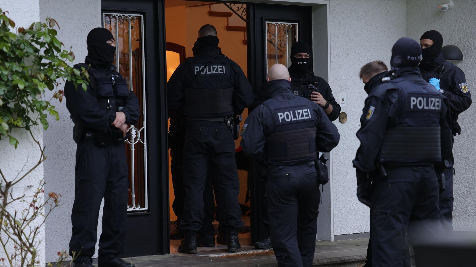 Solingen: Polizeibeamte stehen an einem Gebäude, das durchsucht wird.