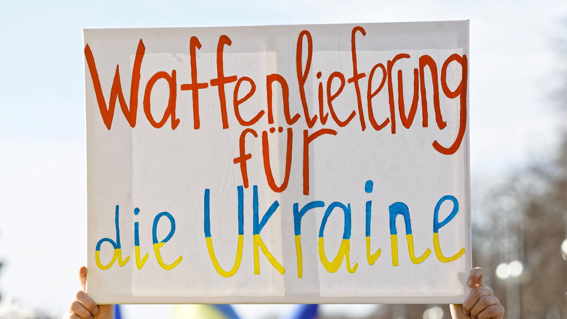 Ein Plakat mit der Forderung "Waffenlieferung für die Ukraine" wird hochgehalten.