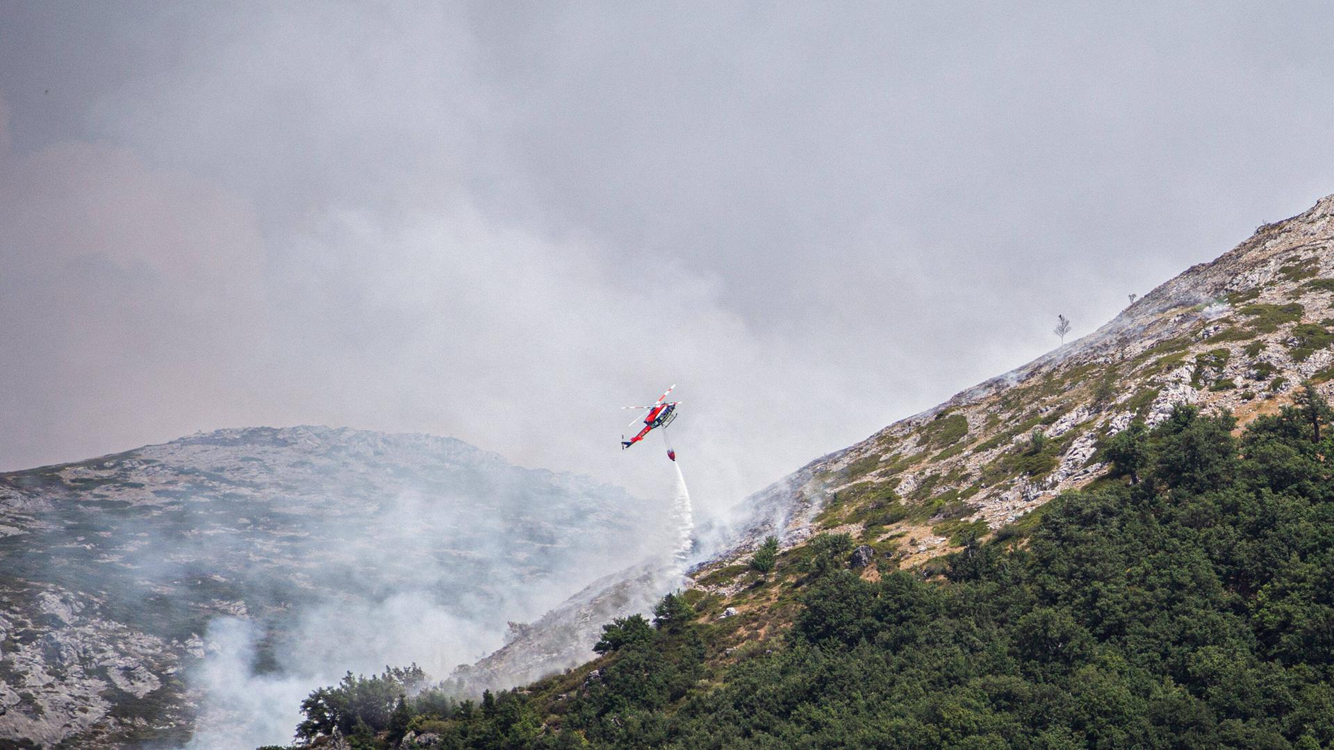 August 10, 2022, Boca de HuÃÆrgano, Leon, Spain: A firefighting helicopter drops water on a large wildfire in Boca de Hu