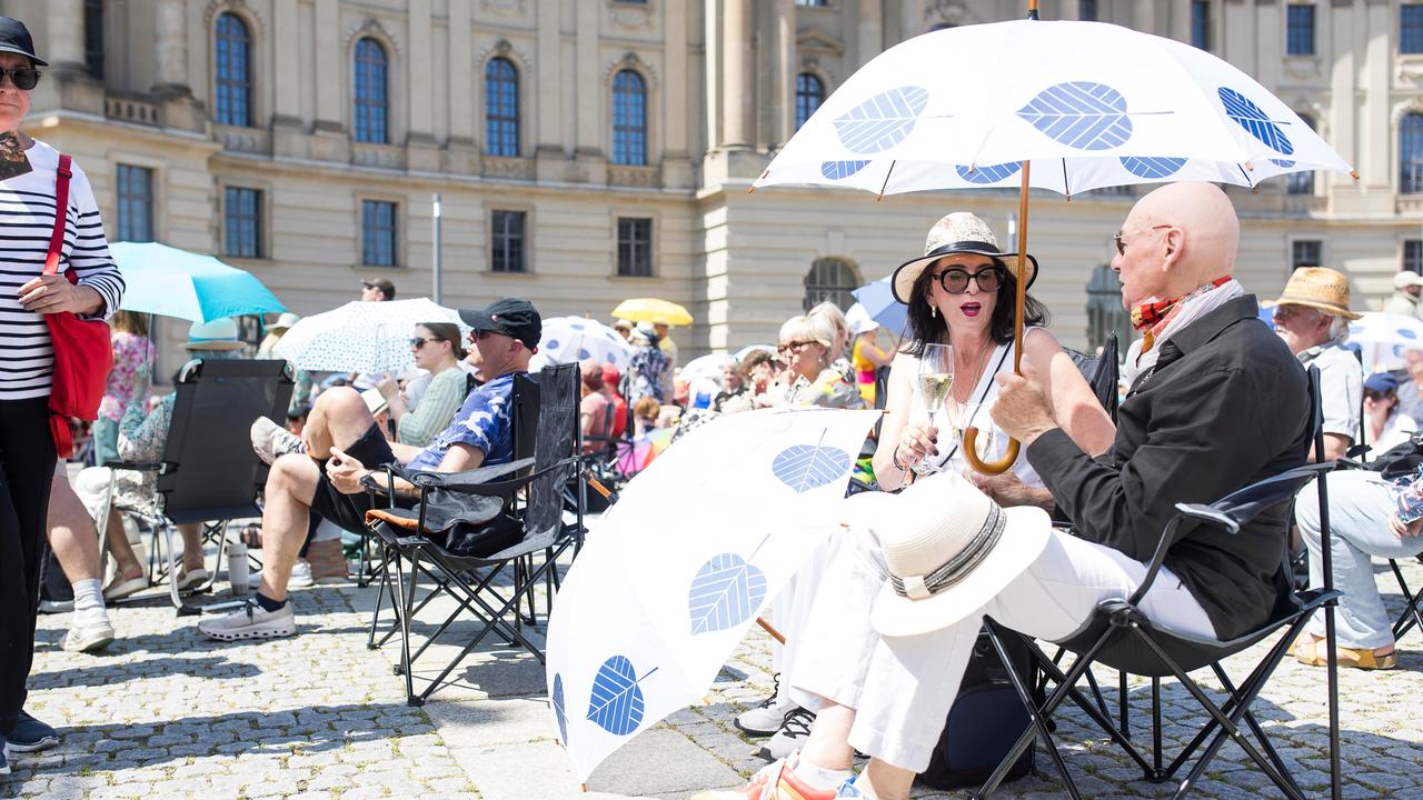 Zwei Besucher unter einem Schirm bei der Staatsoper für alle auf dem Bebelplatz in Berlin. 