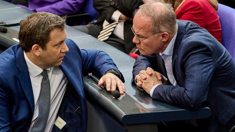 Klingbeil und Miersch im Gespräch. Sie sitzen sich im Bundestag gegenüber und schauen einander an.