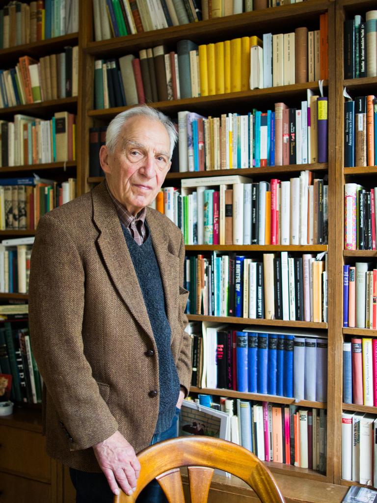 Dieter Wellershoff steht in seiner Wohnung vor einem wandfüllendem Bücherregal.