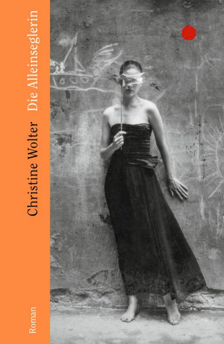 Das Cover vo "Die Alleinseglerin" zeigt eine Frau mit einem schwarzen, schulterfreiem Kleid, welche sich mit einer Maske das Gesicht bedeckt. 