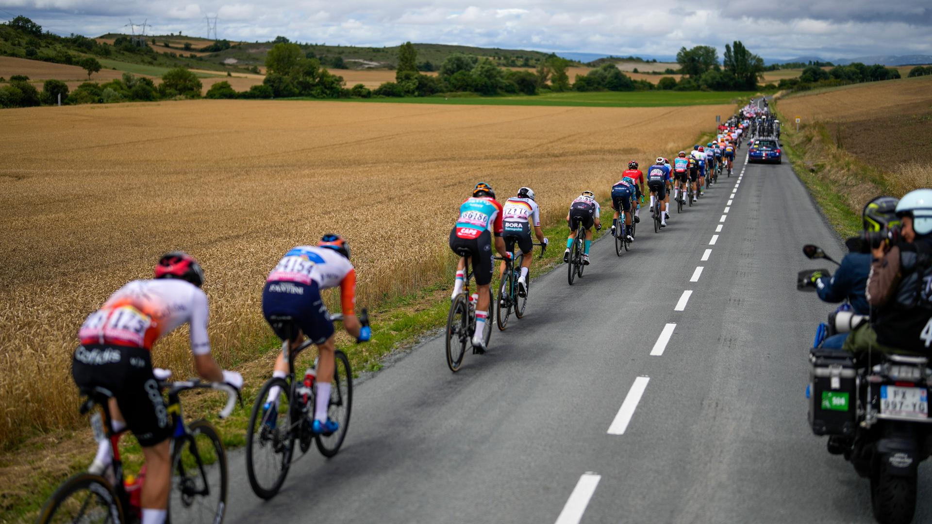Die Fahrer bei der 2. Etappe der Tour de France 2023 von Vitoria-Gasteiz nach San Sebastian. Die Radfahrer auf einer Landstraße, sie fahren an Feldern vorbei. Die Fahrer bei der 2. Etappe der Tour de France 2023 von Vitoria-Gasteiz nach San Sebastian. Die Radfahrer auf einer Landstraße, sie fahren an Feldern vorbei.