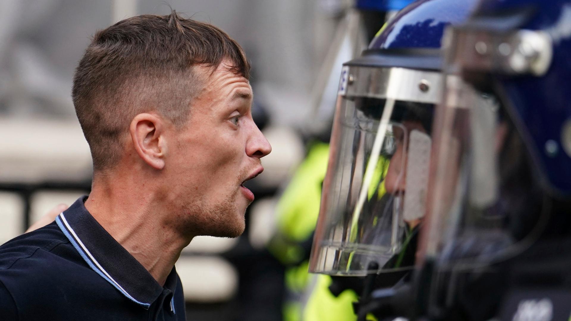 Konfrontative Szene zwischen einem Demonstranten und einem Polizeibeamten bei Protesten im Sommer 2024 in London