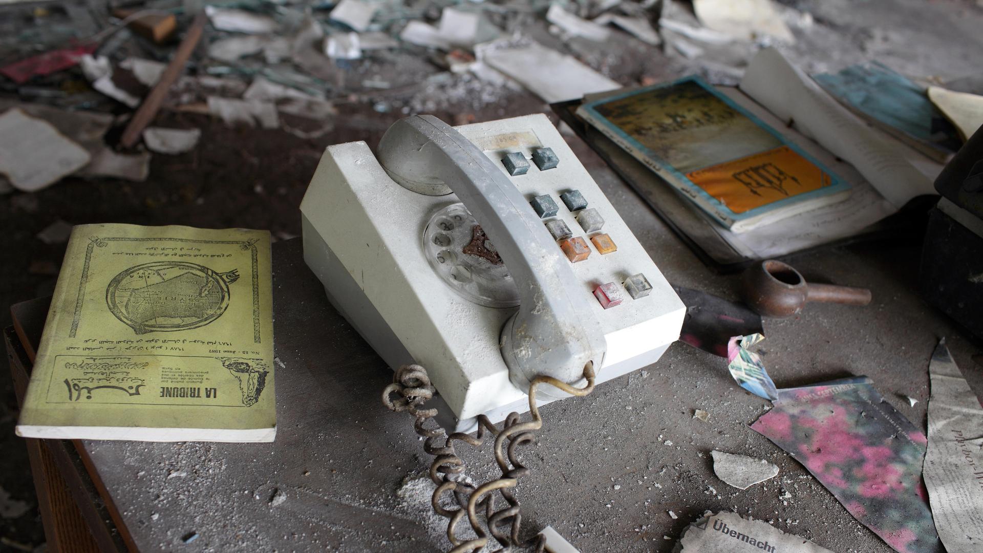 Verwüsteter Schreibtisch mit einem alten Telefonapparat in der ehmaligen irakischen Botschaft in der DDR