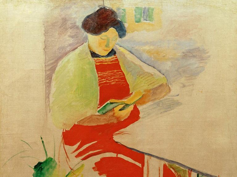 Das Bild "Frau mit roter Schürze auf Balkon (Elisabeth)" von August Macke, 1910. (Elisabeth Macke, geb. Gerhardt, lesend). Öl auf Leinwand, 67 x 49 cm.