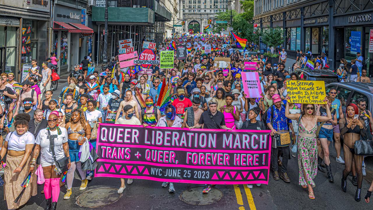 Eine Demonstration für queeres Leben im Juni 2023 in New York City. Die Protestierenden tragen Transparente und viele Farben der queeren Bewegung.