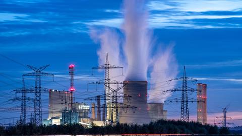 Das Braunkohlekraftwerk der RWE Power AG Kraftwerk im rheinischen Niederaußem. Weiße Wolken steigen aus den Schornsteinen in den Himmel.