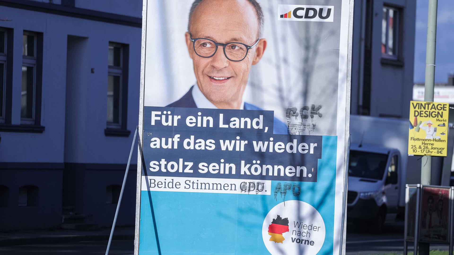 Ein beschmiertes Wahlplakat der CDU ( Christlich-Demokratische Union) für den Spitzenkandidaten Friedrich Merz mit der Aufschrift: "Für ein Land, auf das wir wieder stolz sein können. Beide Stimmen CDU." 