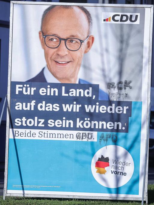 Ein beschmiertes Wahlplakat der CDU ( Christlich-Demokratische Union) für den Spitzenkandidaten Friedrich Merz mit der Aufschrift: "Für ein Land, auf das wir wieder stolz sein können. Beide Stimmen CDU." 