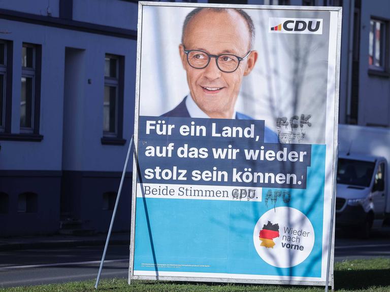 Ein beschmiertes Wahlplakat der CDU ( Christlich-Demokratische Union) für den Spitzenkandidaten Friedrich Merz mit der Aufschrift: "Für ein Land, auf das wir wieder stolz sein können. Beide Stimmen CDU." 