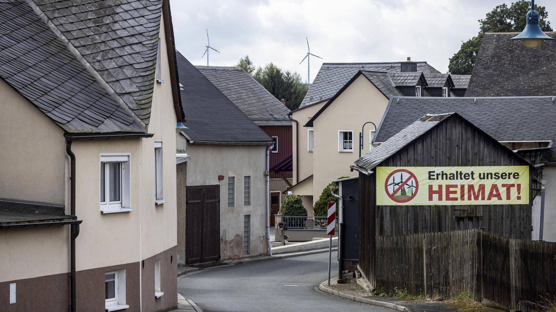 In einem Dorf im ehemaligen Deutsch-Deutschen Grenzgebiet zwischen Thüringen und Bayern hängt ein Protestplakat gegen Windkraftanlagen.