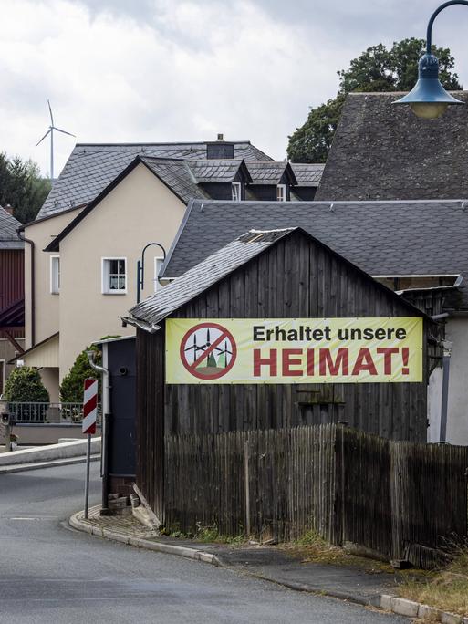 In einem Dorf im ehemaligen Deutsch-Deutschen Grenzgebiet zwischen Thüringen und Bayern hängt ein Protestplakat gegen Windkraftanlagen.