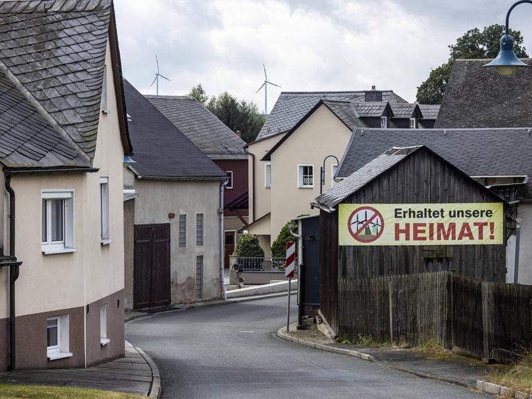 In einem Dorf im ehemaligen Deutsch-Deutschen Grenzgebiet zwischen Thüringen und Bayern hängt ein Protestplakat gegen Windkraftanlagen.