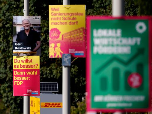 Wahlplakate zur Kommunalwahl 2025 in Nordrhein-Westfalen hängen in Frechen bei Köln. Zu sehen sind Plakate der Grünen, der FDP, der CDU und der Freien Wähler. 