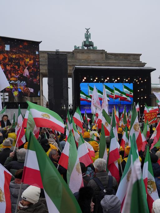 Demonstranten mit Plakaten und Transparenten am Brandenburger Tor in Berlin. 