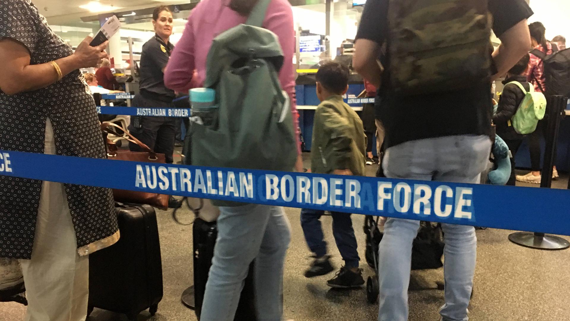 Flugpassagiere bei der EInreise in Brisbane. Im Vordergrund eine Absperrung der Border Force.